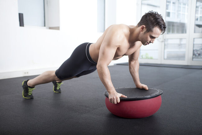 El cruce alternado de piernas es uno de los más intensos ejercicios con bosu para tus abdominales.