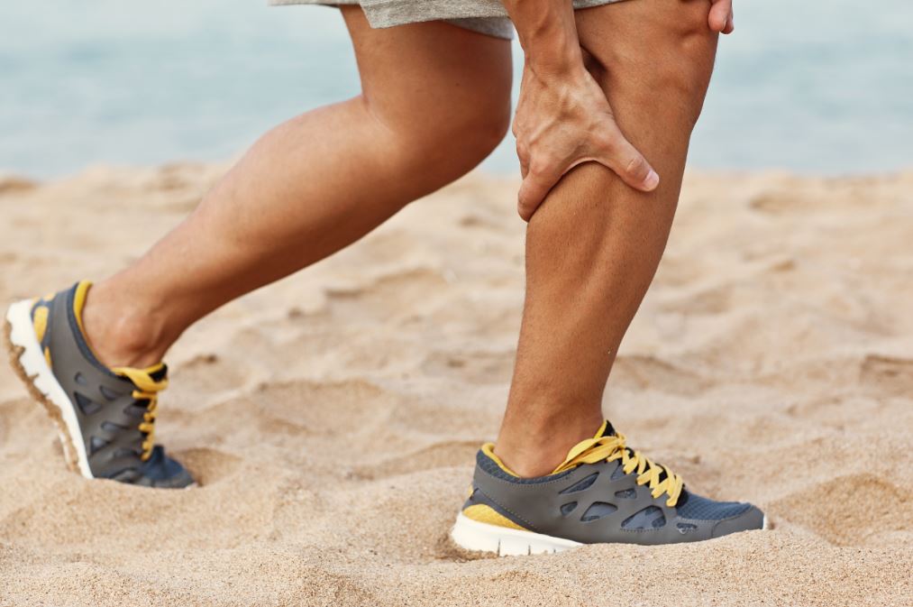 Hombre con calambre muscular en el gemelo.