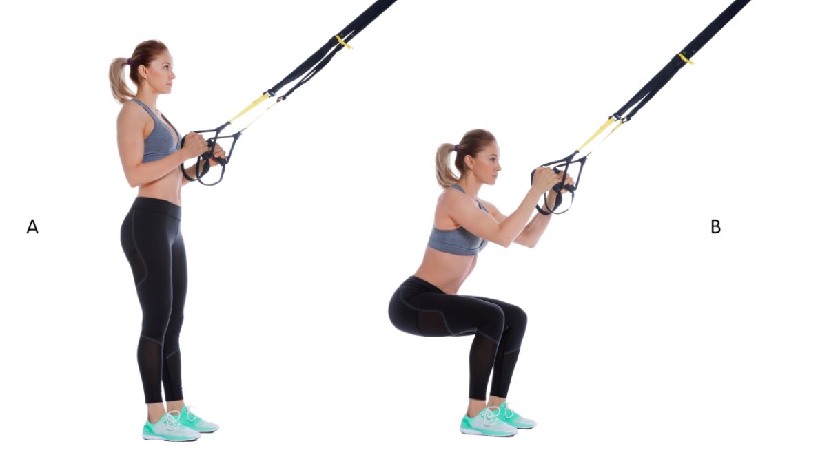 Mujer explica como hacer sentadillas TRX.