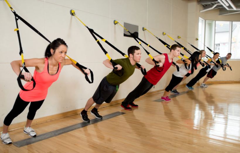 Personas haciendo entrenamiento TRX.