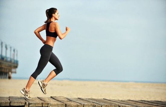 Chica corriendo al lado de la playa.