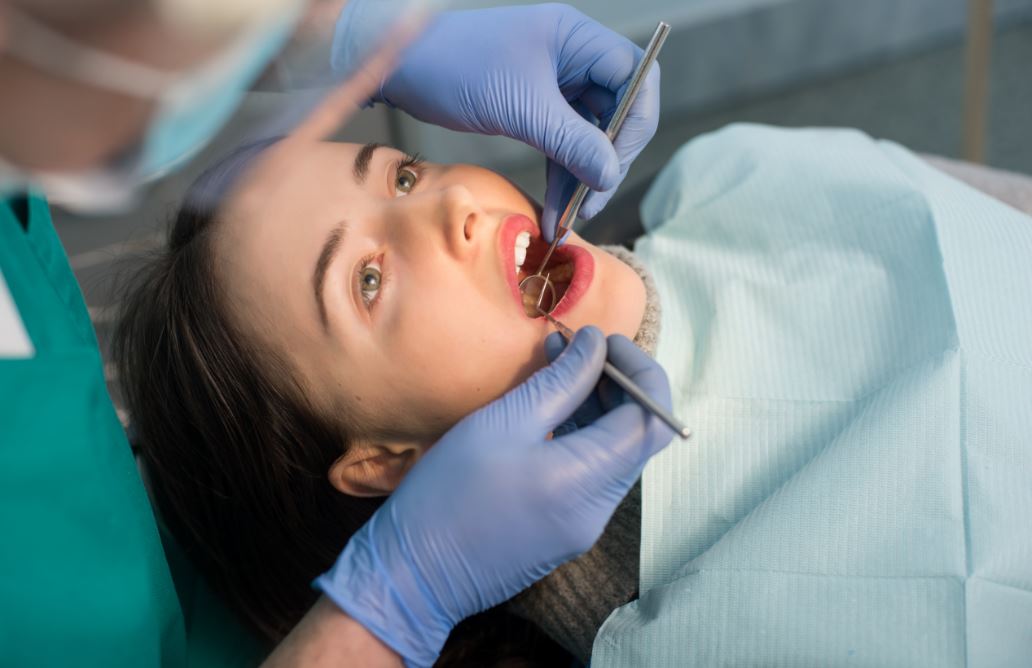Chica pasando una revisión de caries en el dentista.