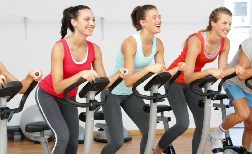 Varias chicas practicando Spinning en un gimnasio.