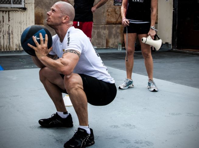 Chico haciendo ejercicio con balón medicinal.
