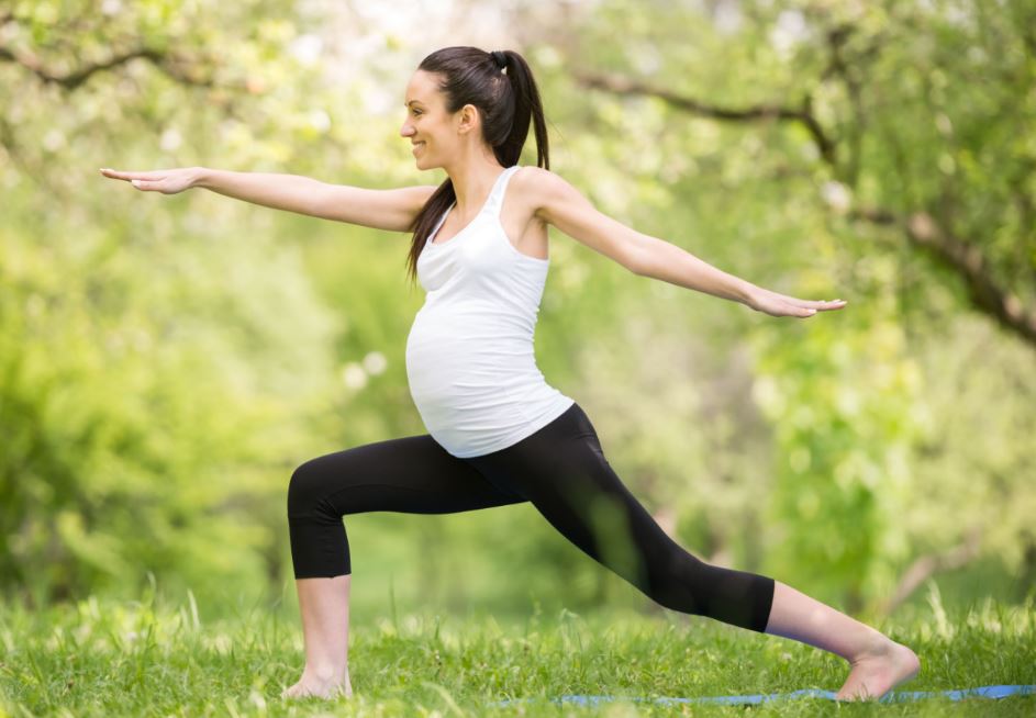 Mujer embarazada hace yoga.
