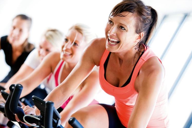 Mujeres haciendo ciclo-indoor en el gimnasio.