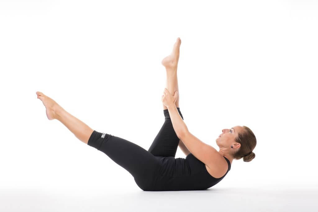 Sube un poco el dorso y eleva la pierna derecha para que la rodilla toque tu hombro izquierdo.