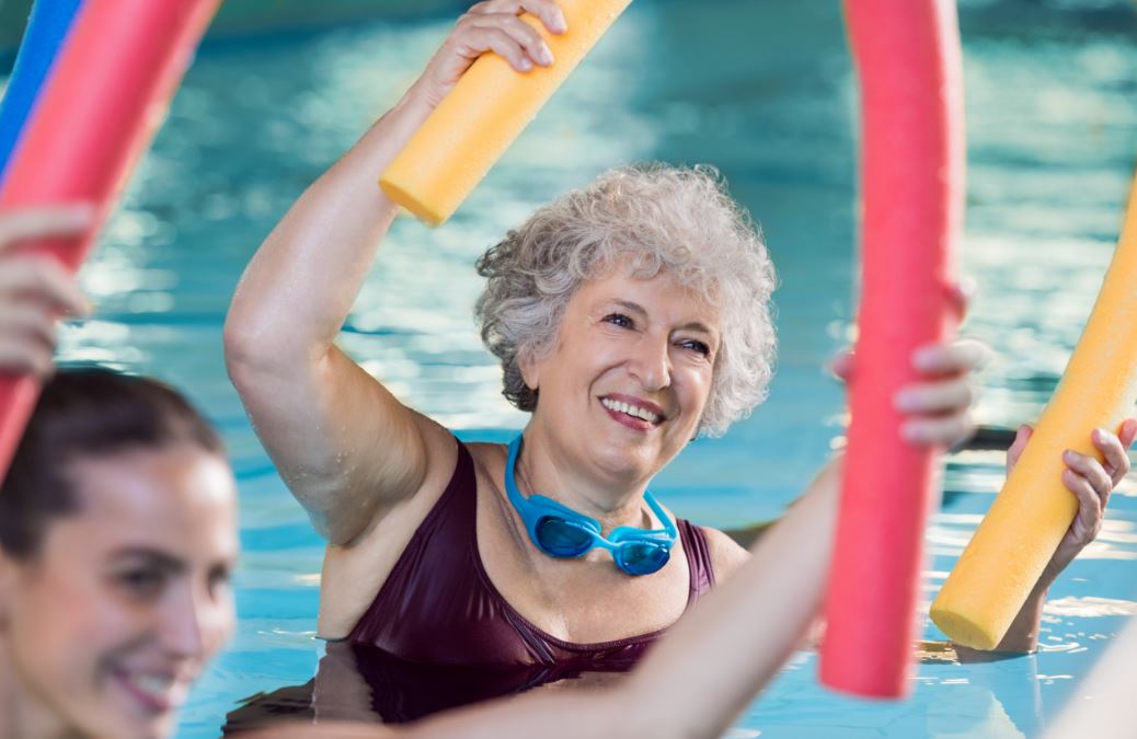 Señora mayor haciendo aquagym en la piscina.