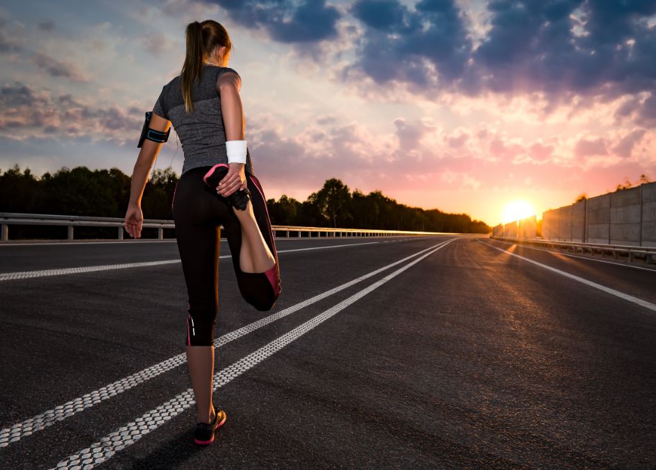 Una chica estirando para correr.