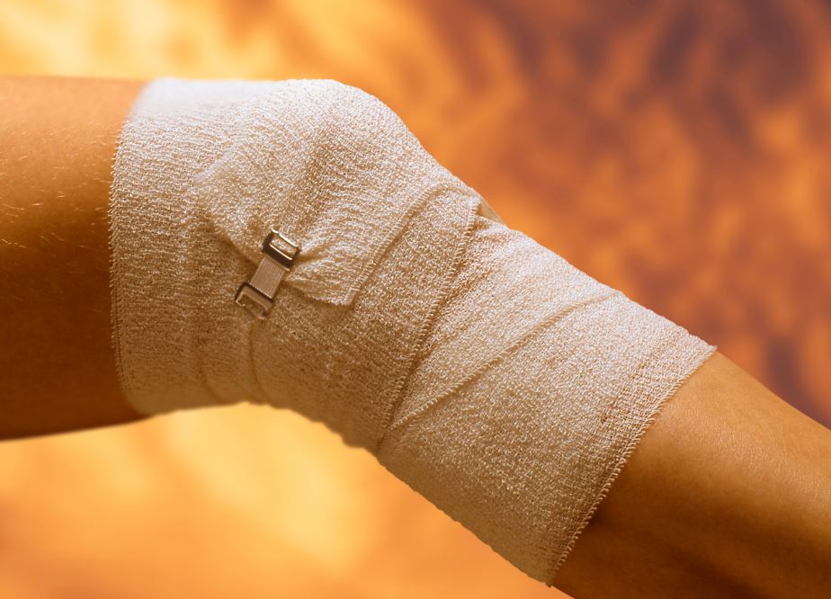 Chica con rodilla vendada por lesión.