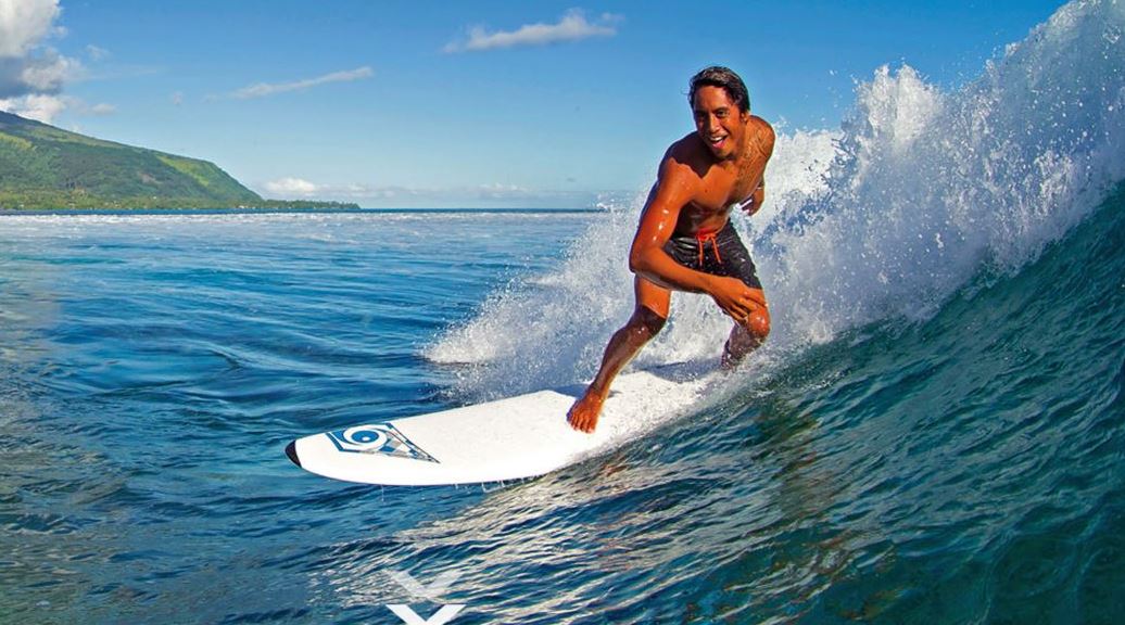 Chico subido a una tabla de surf.