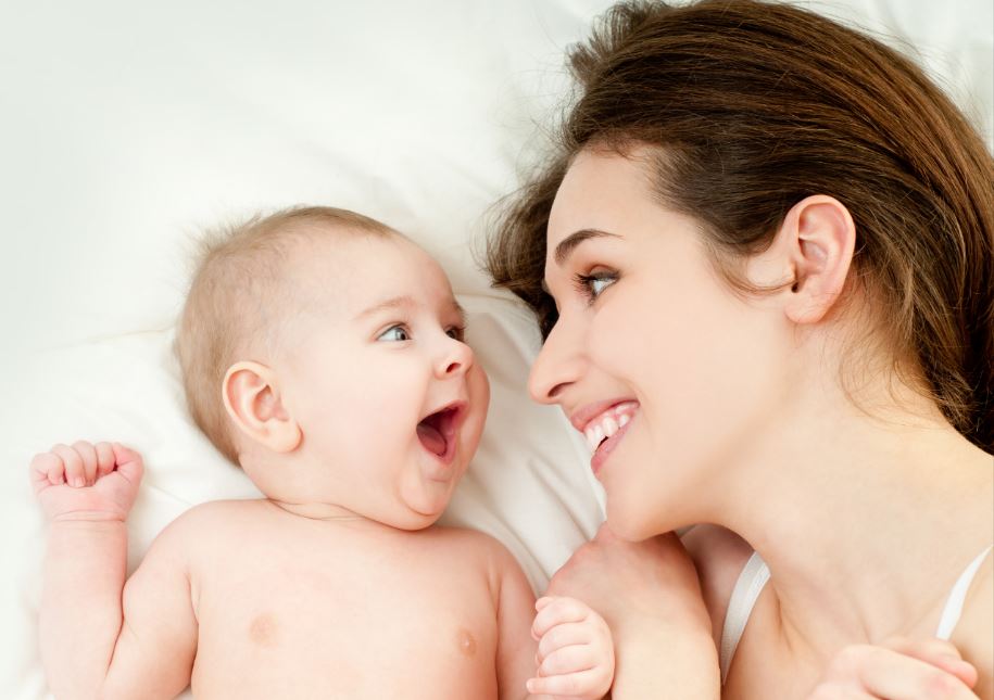 Mamá y bebé sonriendo juntos.