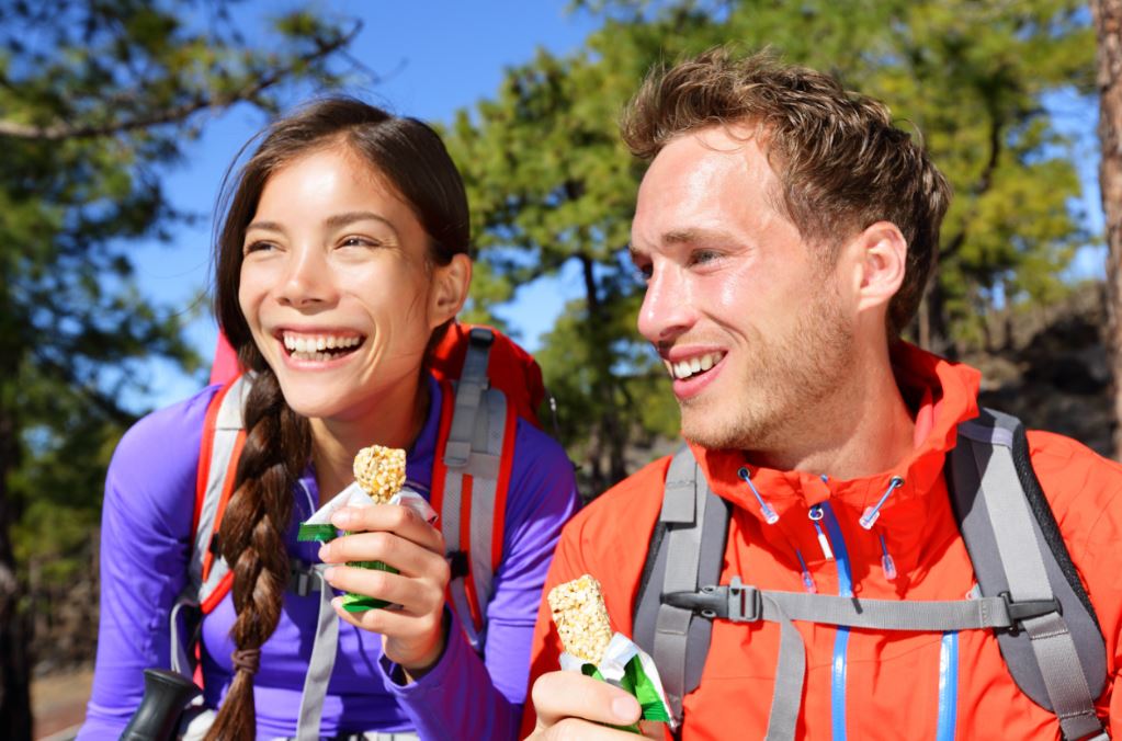 Pareja de deportistas con barritas de proteínas.