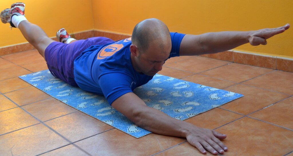 Para este ejercicio, tenemos que levantar el brazo y la pierna en posición opuesta, con el vientre como apoyo.