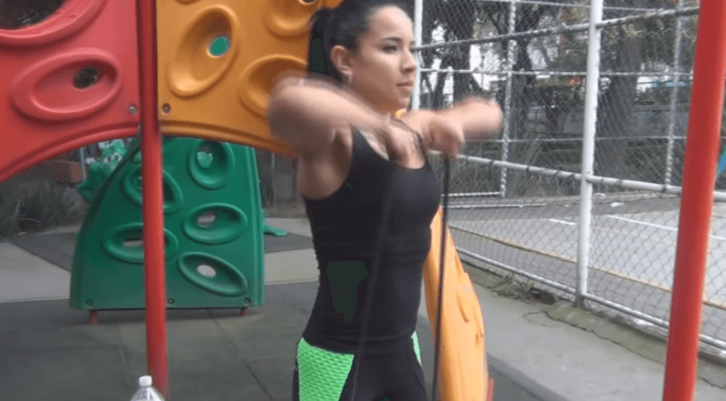 El remo al cuello, uno de los principales ejercicios de hombros con goma elástica.