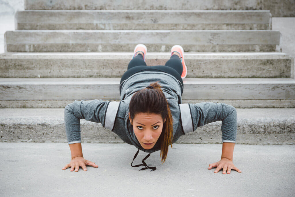 Mujer realizando flexiones de brazo inclinadas.