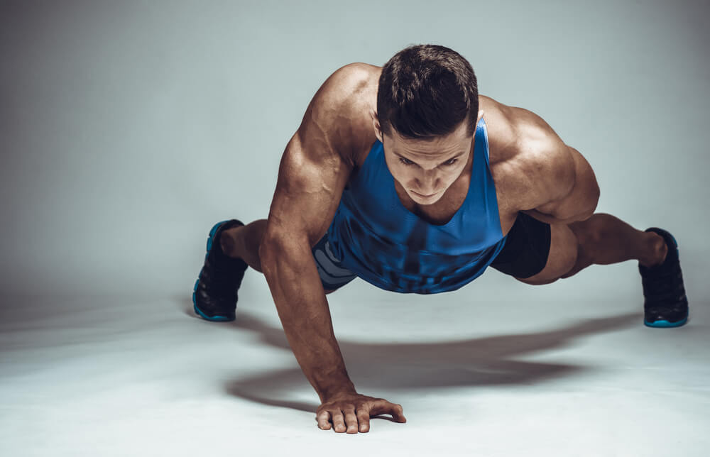 hombre haciendo flexiones una sola mano