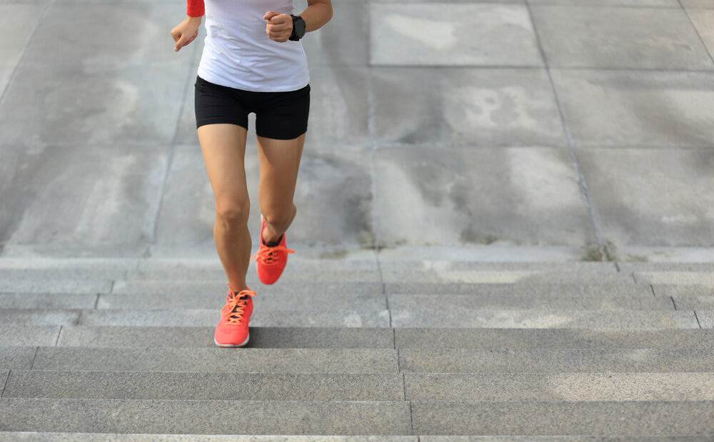Mujer subiendo escaleras para ganar velocidad y potencia.