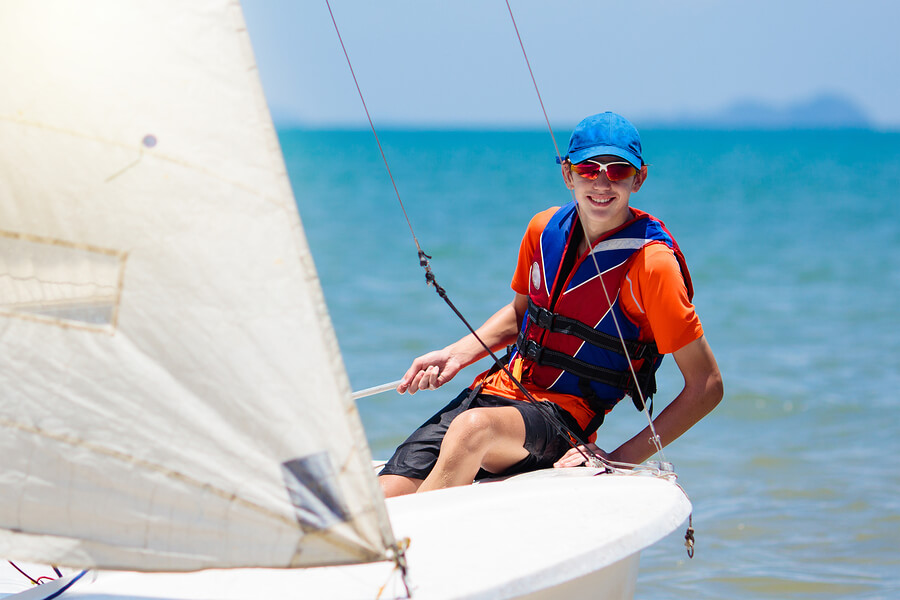 Joven haciendo vela, uno de los deportes acuáticos más populares.