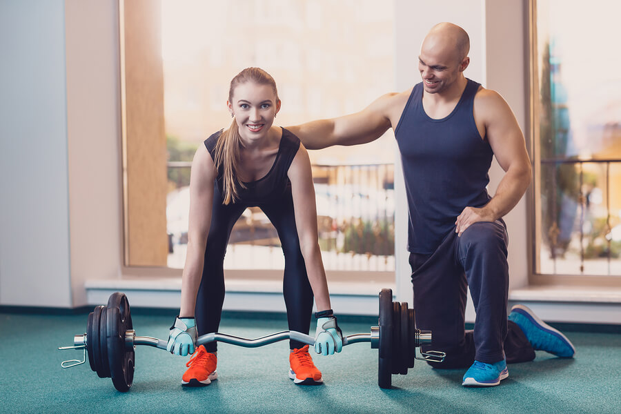 Chica realizando trabajos de fuerza en gimnasio.