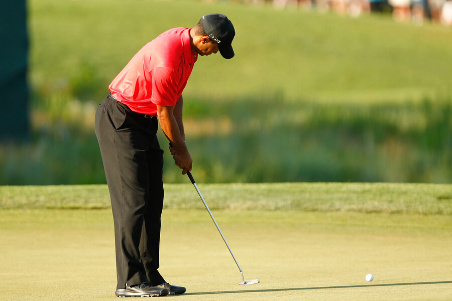 Woods realizando un tiro en competencia de golf.