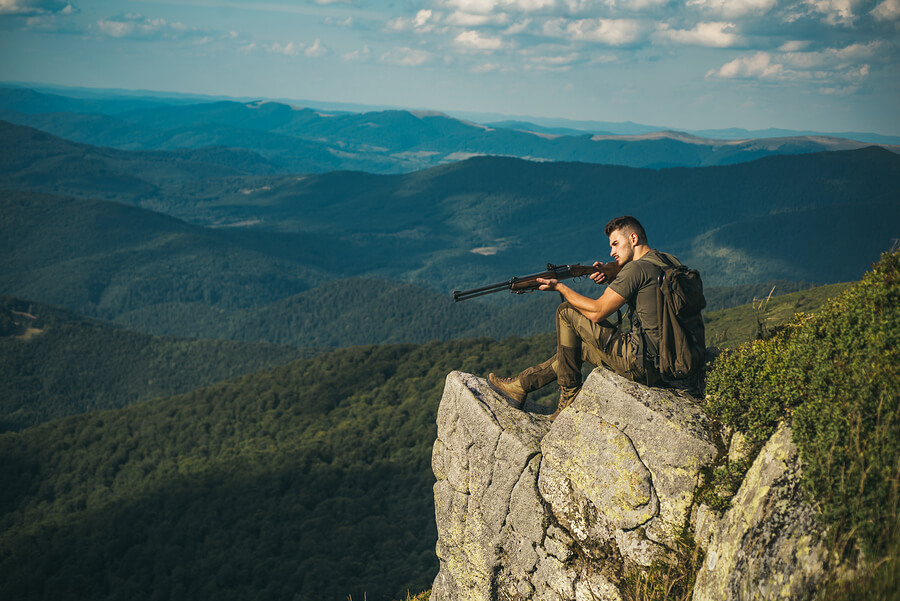 Hombre practicando caza deportiva desde una montaña.