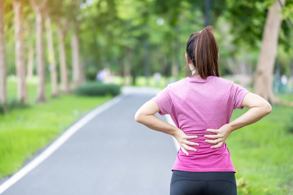 Mujer con dolor de espalda después de entrenar y correr