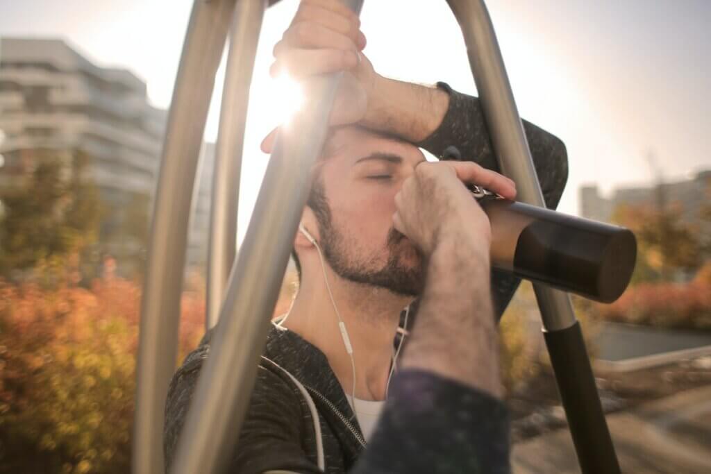 Hombre bebiendo agua en una botella.