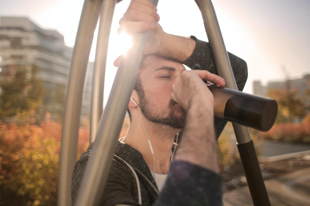 Hombre bebiendo agua en una botella.