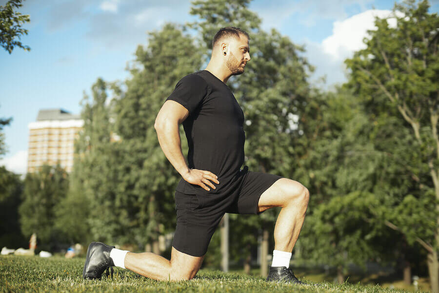 Hombre haciendo zancada entrenando al aire libre.