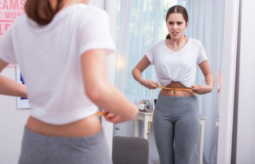 Mujer aplica la fórmula de Harris-Benedict para medir su gasto calórico diario.