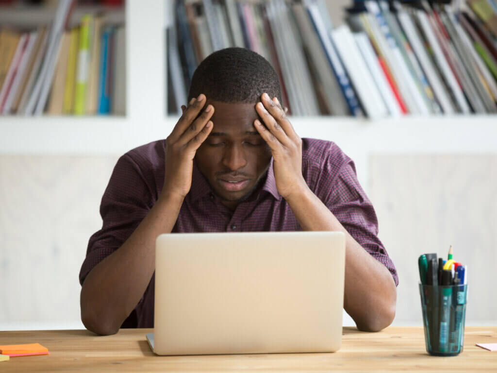 Hombre estresado frente a su computadora.