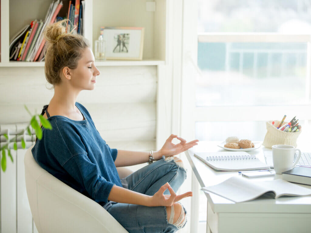 Joven que hace meditación antes de comenzar a estudiar.