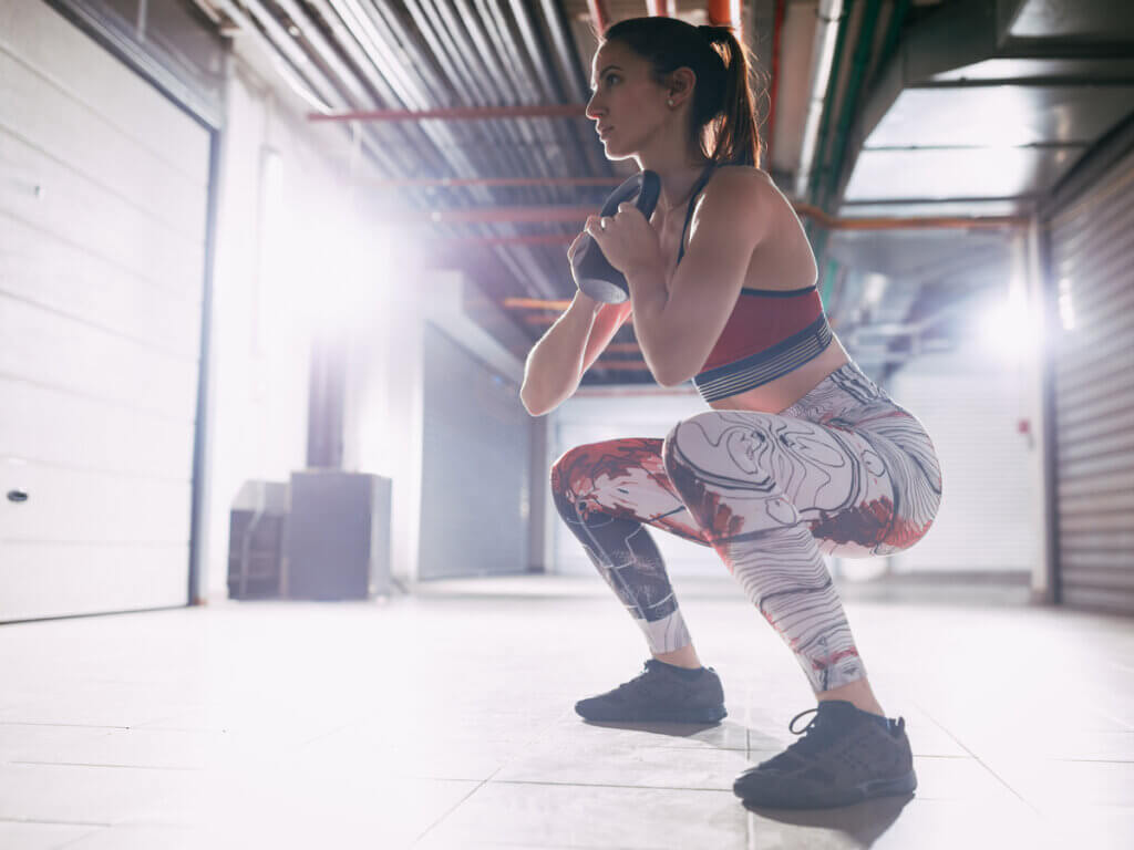 Mujer realizando sentadilla goblet en su rutina de piernas.