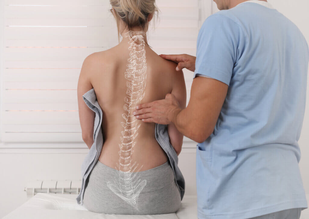 Fisioterapeuta trabaja con una paciente con escoliosis.