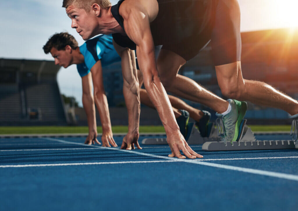 Atletas se preparan para una carrera en atletismo.