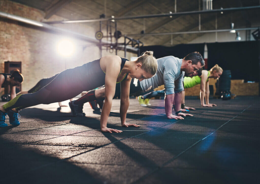 Grupo de personas fitness haciendo flexiones de pecho.