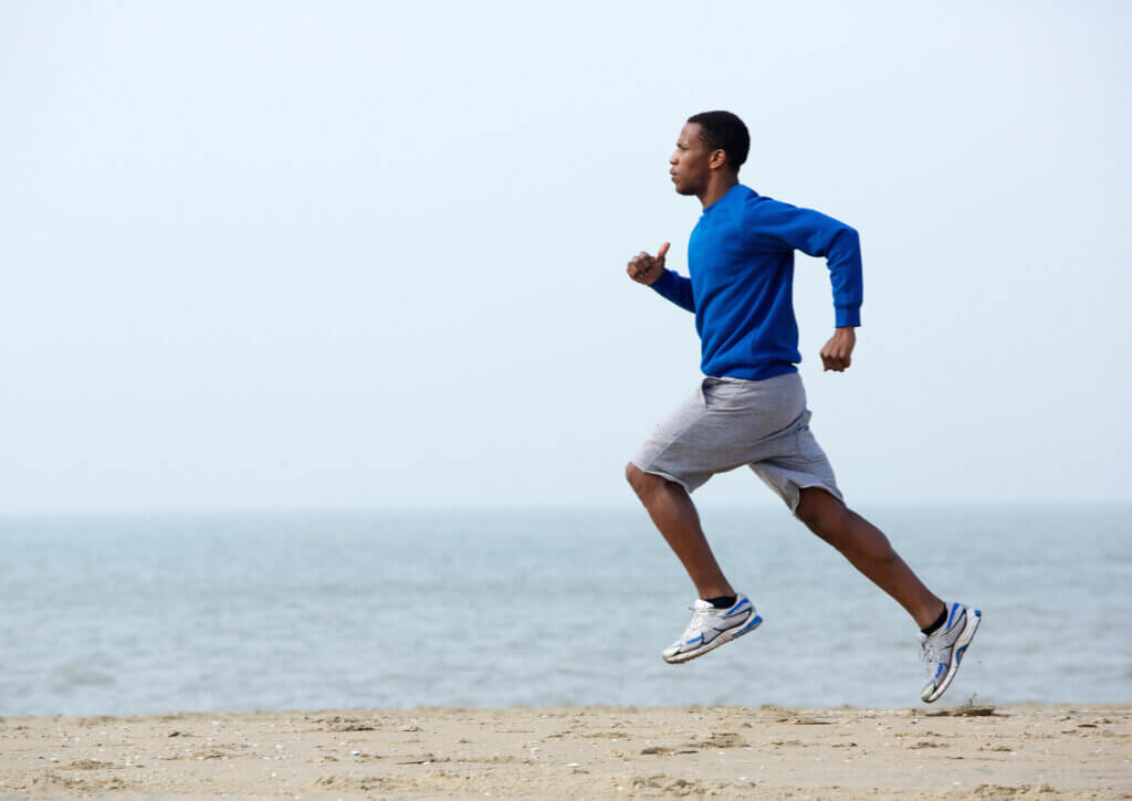 Hombre realizando entrenamiento de resistencia en la playa.