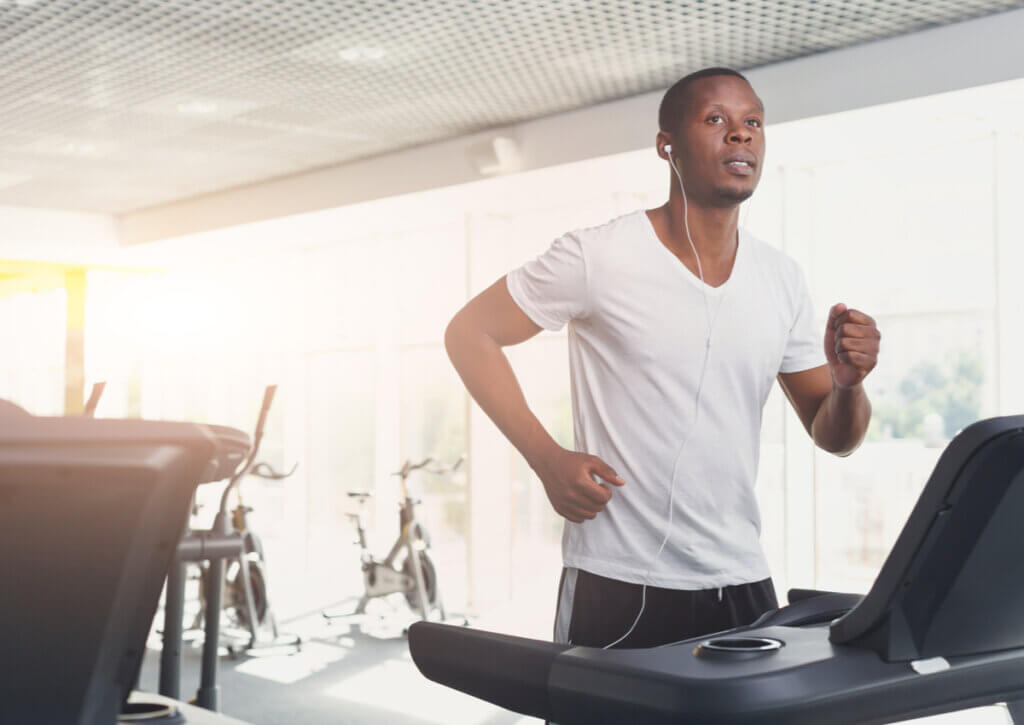 Hombre siguiendo recomendaciones médicas para el ejercicio aeróbico en la cinta.