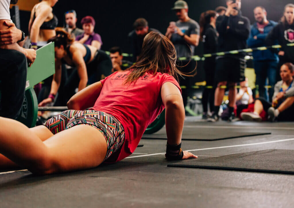 Mujer haciendo burpees durante una competencia de crossfit.