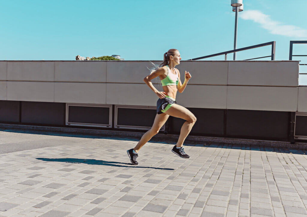 Mujer runner realizando calentamiento preventivo con intensidad.