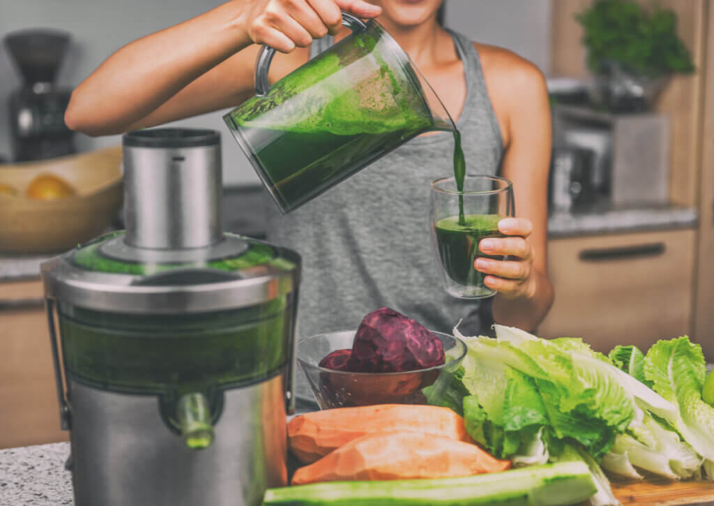 Mujer tomando un zumo de verduras.
