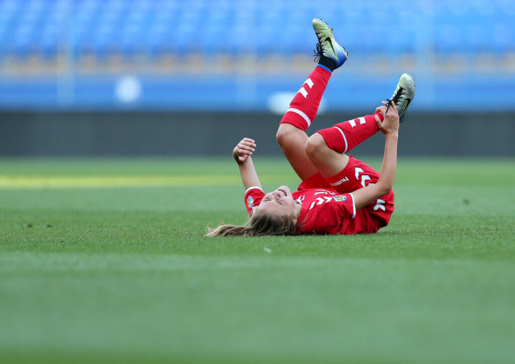 Mujer sufre una lesión en el tobillo en un partido de fútbol.