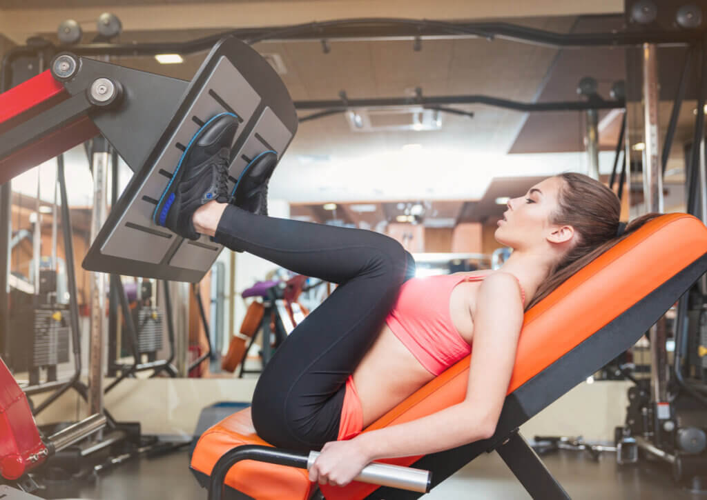 Mujer realizando prensa dentro de su rutina de piernas.