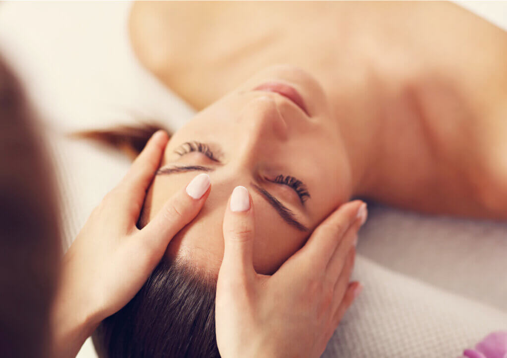 Mujer recibe un masaje en la cara para la relajación de los músculos.