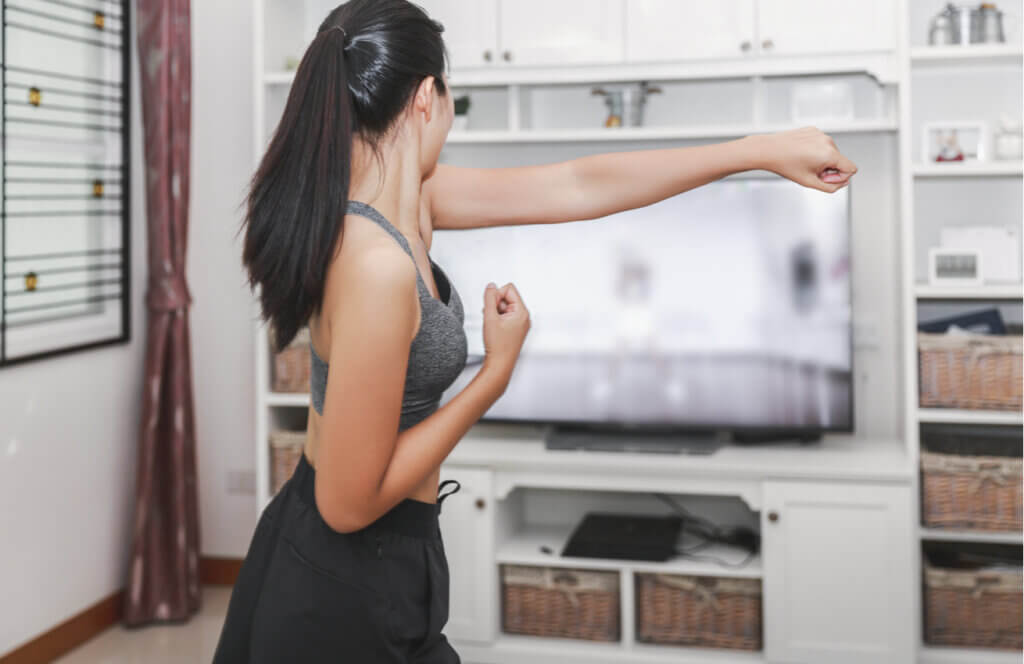 Mujer haciendo sombras de boxeo para quemar más calorías en casa.