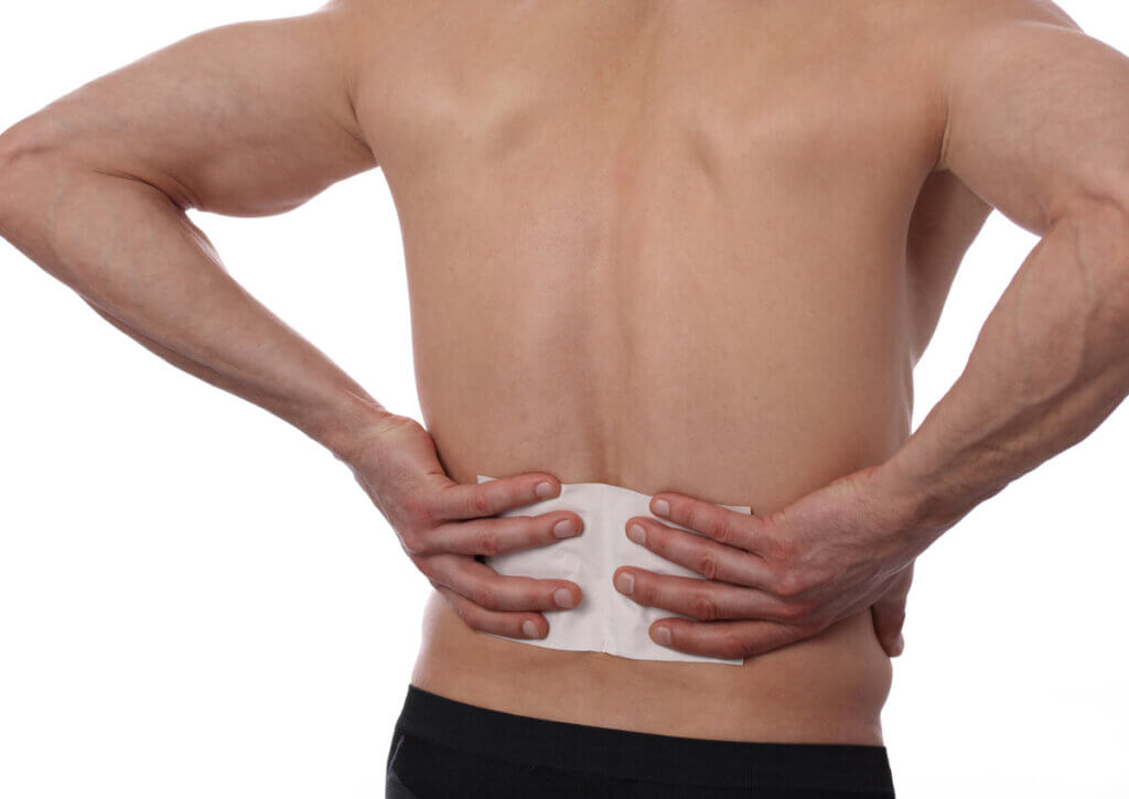 Hombre con un parche para el dolor en la espalda.