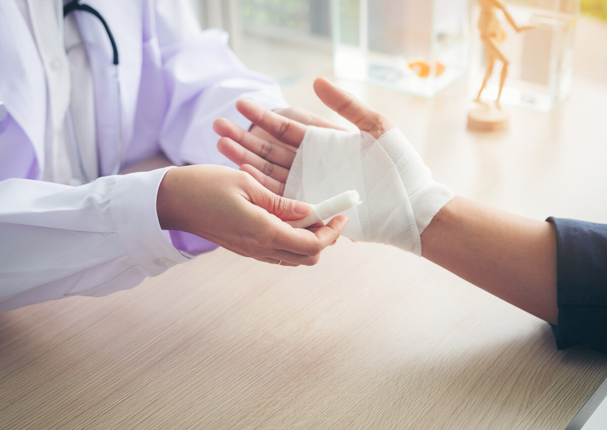 Doctor aplica una venda sobre una quemadura por fricción.