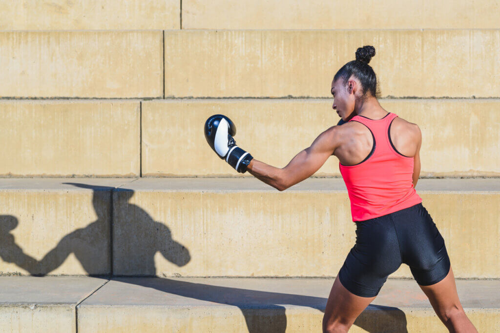 Mujer boxeando y lanzando un gancho.