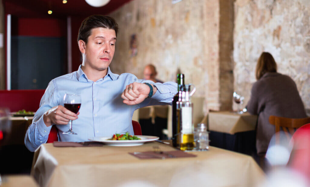 Hombre que mira su reloj para cumplir con la cronodieta.